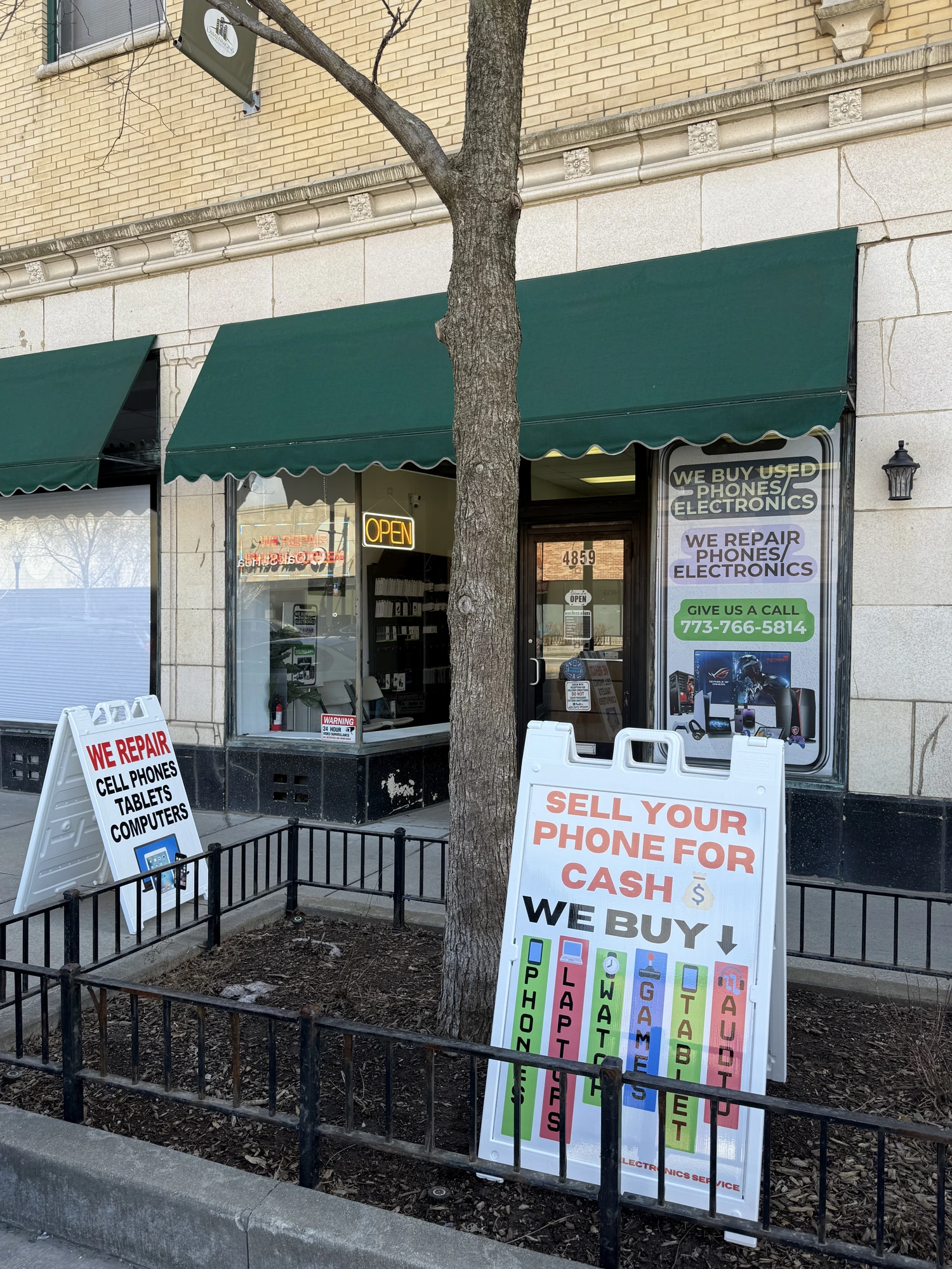 2A Electronics storefront on W Irving Park Rd, Chicago with 'We Fix iPhones' and 'Sell Your Phone for Cash' signs