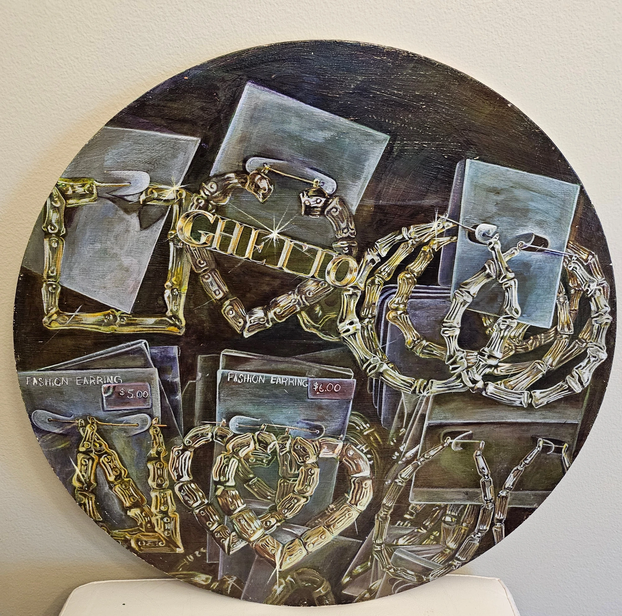 Circular mixed-media artwork with gold jewelry and display cards