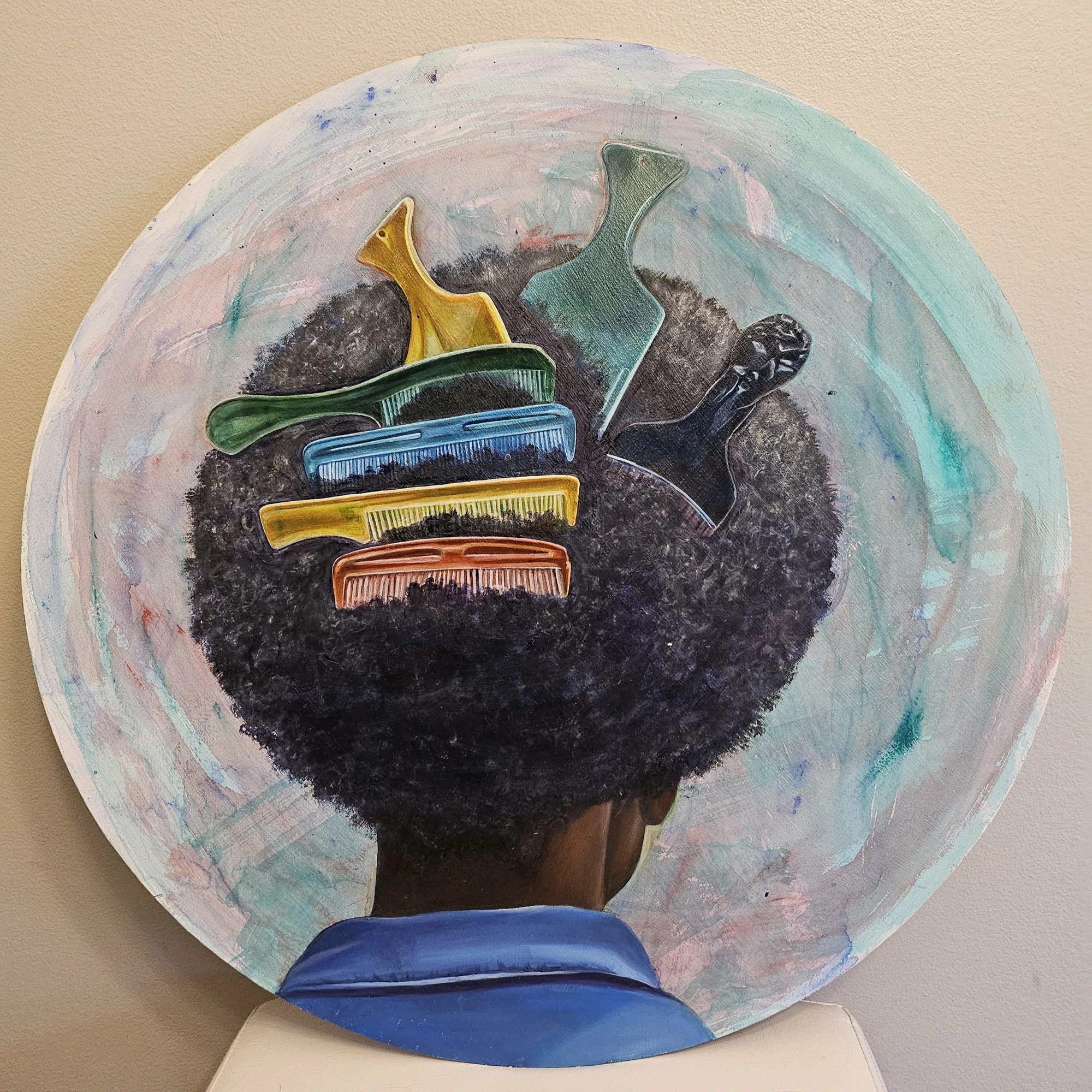 Artwork detail with a figure's afro adorned by brightly colored combs