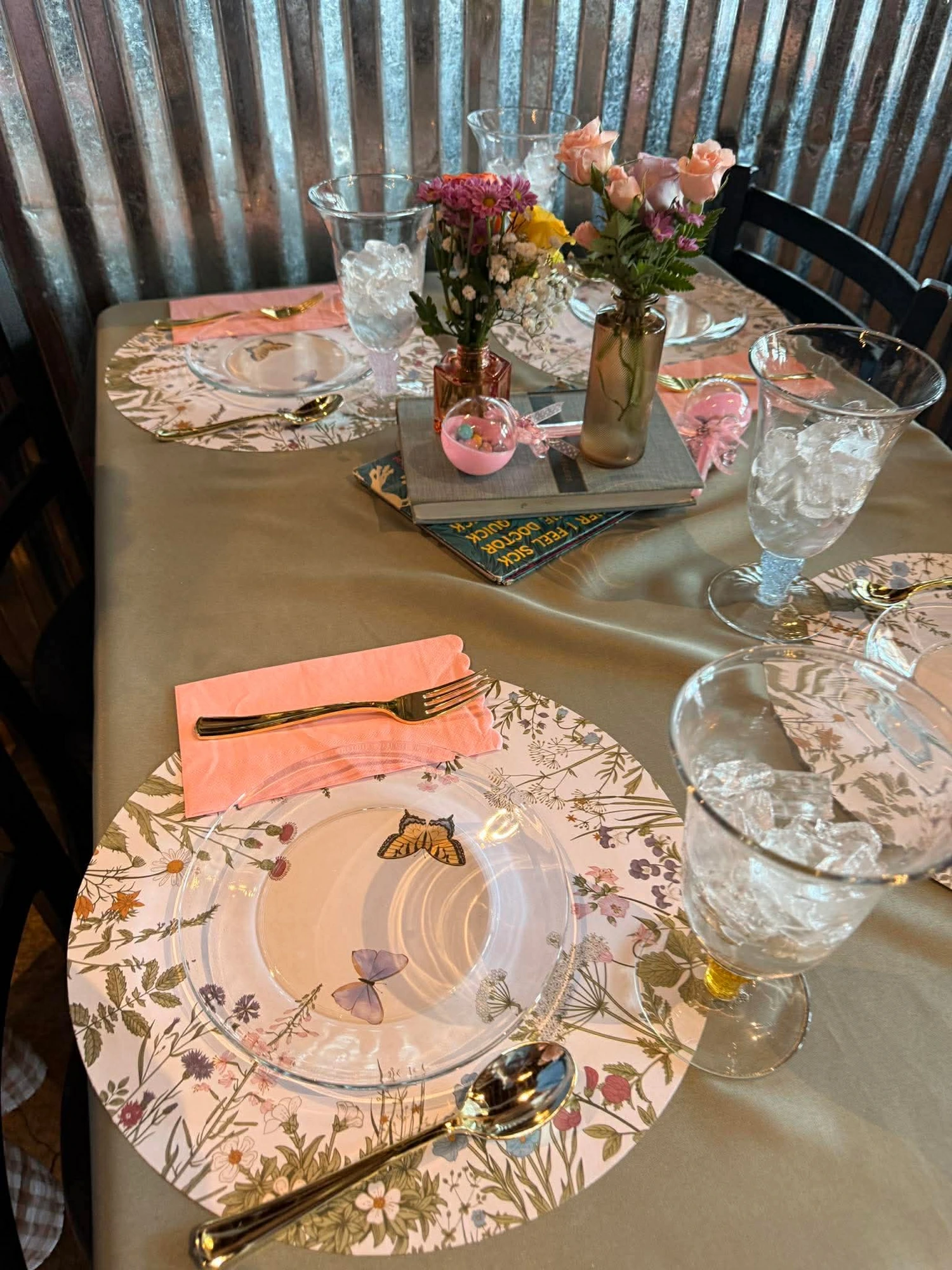Table setting with botanical placemats, butterfly glass plates and gold flatware